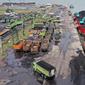 Alat berat (kanan) digunakan untuk memuat batu bara ke truk di Pelabuhan Karya Citra Nusantara (KCN) Marunda, Jakarta, 17 Januari 2022. Indonesia melonggarkan larangan ekspor batu bara. (ADEK BERRY/AFP)