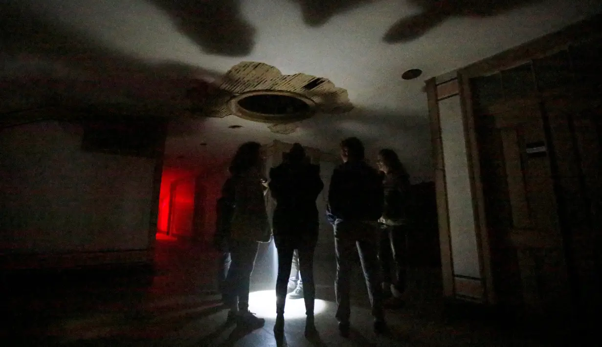Pengunjung mendengarkan instruksi saat berada didalam rumah hantu Quinta Nova da Assuncao di Belas, Portugal (13/5). Pengunjung akan diajak tur di dalam rumah kosong Quinta Nova da Assuncao. (REUTERS/Rafael Marchante)