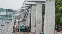 Pekerja menggunakan alat berat untuk menyelesaikan proyek kereta api ringan atau light rail transit (LRT) Jabodetabek, Bekasi, Sabtu (25/2). (Liputan6.com/Gempur M. Surya)