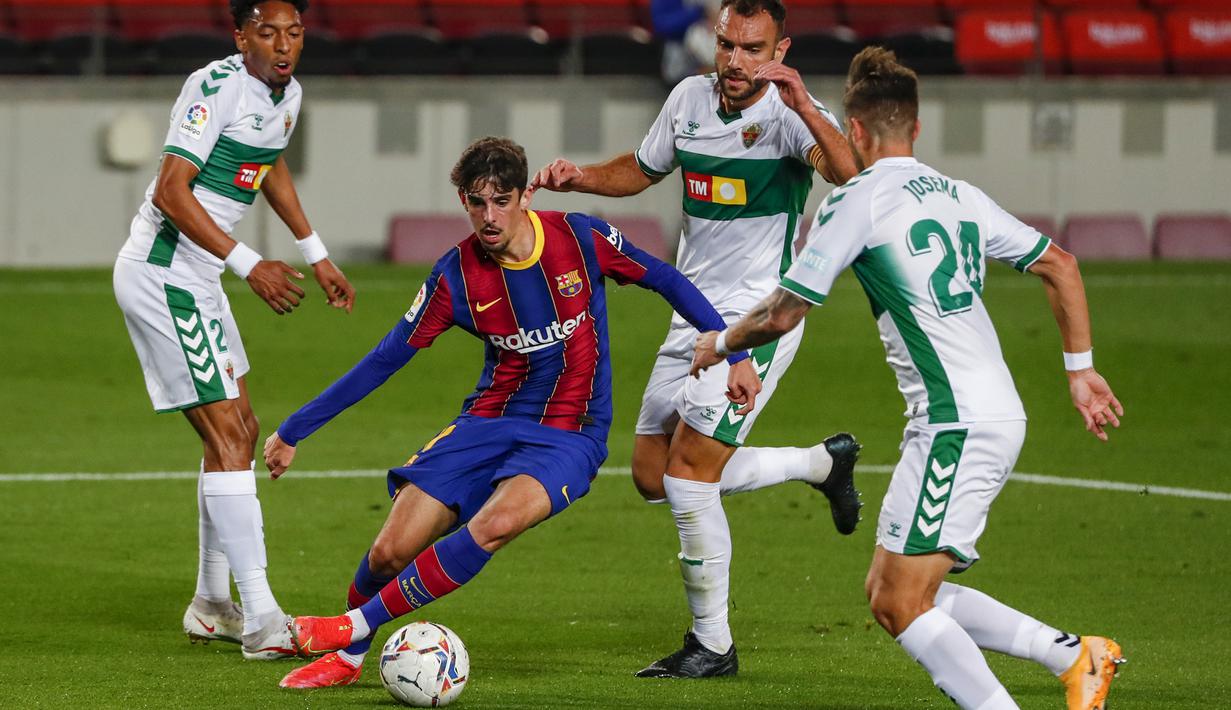 Striker Barcelona, Francisco Trincao (tengah) menguasai bola dikepung tiga pemain Elche dalam laga lanjutan Liga Spanyol 2020/21 pekan ke-24 di Camp Nou Stadium, Barcelona, Rabu (24/2/2021). Barcelona menang 3-0 atas Elche. (AP/Joan Monfort)