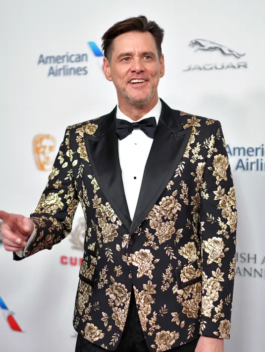 Aktor komedi Jim Carrey berpose saat tiba menghadiri acara BAFTA Los Angeles Britannia Awards 2018 di Beverly Hilton di Beverly Hills, California (26/10). Jim Carrey tampil keren mengenakan jas bermotif kembang. (AFP Photo/Neilson Barnard)