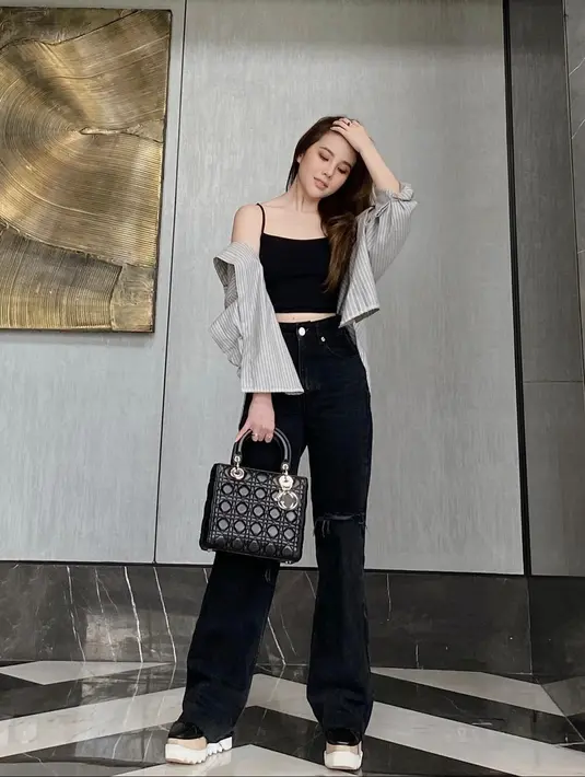 <p>Inner top dan celana hitam sangat ciamik juga dipadu padankan dengan kemeja motif striped berwarna nude. (instagram/agatha_chelsea)</p>