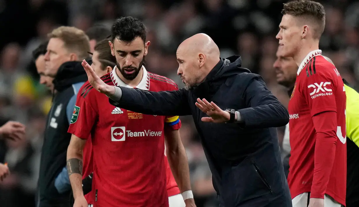 <p>Pelatih Kepala Manchester United, Erik Ten Hag (tengah) berbicara dengan Bruno Fernandes (kiri) saat pertandingan sepak bola final Piala Liga Inggris antara Manchester United dan Newcastle United di Stadion Wembley di London, Minggu, 26 Februari 2023. Manchester United sukses mengakhiri puasa gelar pada Minggu (26//2023). MU menjadi juara Piala Liga Inggris atau Carabao Cup 2022/2023 setelah menang 2-0 atas Newcastle United di Stadion Wembley, London. (AP Photo/Alastair Grant)</p>