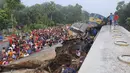 Orang-orang berkumpul di dekat gerbong kereta yang rusak parah setelah dua kereta yang melaju bertabrakan di distrik Brahmanbaria, 82 kilometer (51 mil) timur ibukota, Dhaka, Bangladesh, Selasa (12/11/2019). Sekitar 16 orang tewas dan 60 lainnya terluka akibat kecelakaan tersebut. (AP Photo)