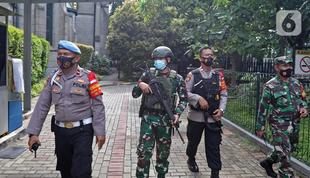 Sejumlah anggota gabungan melakukan pengamanan saat perayaan Paskah di Gereja Katedral, Jakarta, Jumat (2/4/2021). Pengamanan diperketat untuk mengatisipasi aksi teror menyusul adanya serangkaian teror dalam sepekan terakhir. (Liputan6.com/Herman Zakharia)