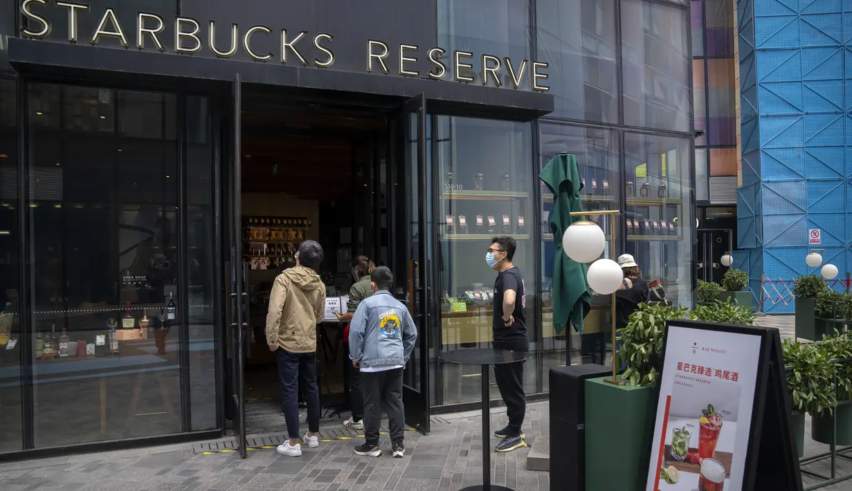 <p>Orang-orang yang memakai masker berbaris di kafe Starbucks yang buka hanya untuk pesanan bawa pulang setelah banyak bisnis diperintahkan untuk tutup sebagai bagian dari pembatasan COVID-19 di distrik Chaoyang di Beijing, Sabtu, 14 Mei 2022. China dengan tegas menolak kritik terhadap kebijakan "nol-COVID" tanpa kompromi. (AP Photo/Mark Schiefelbein)</p>