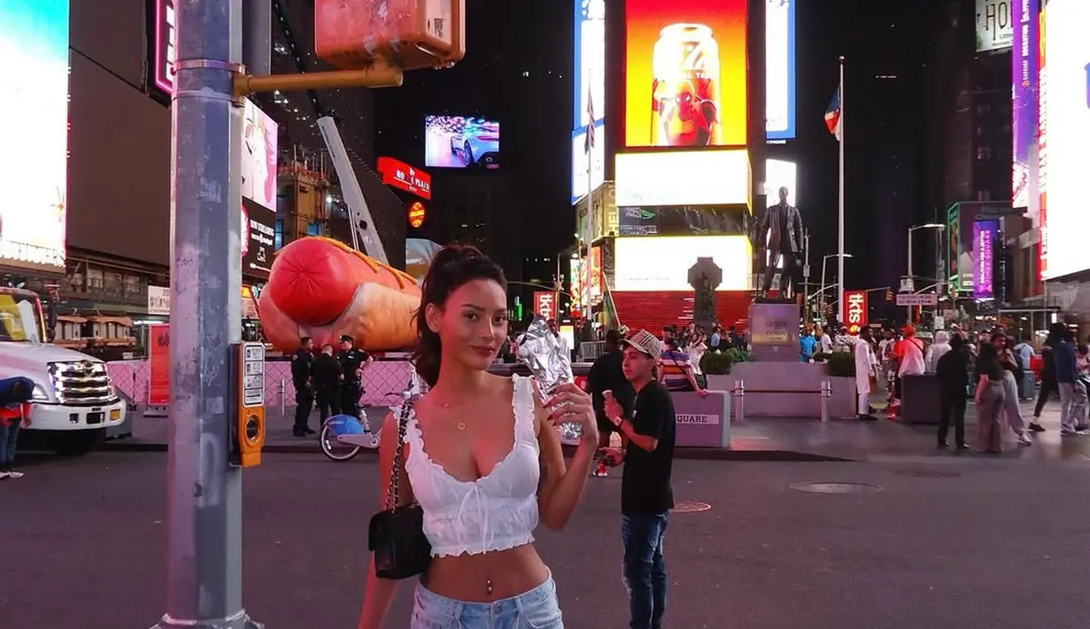 Liburan di New York, Erika Carlina kenakan sneakers untuk tampilan dualismenya. Ia pdaukan sneakers putih abu-abu dengan croptop baby doll dan baggy light jeans [@eri.carl]