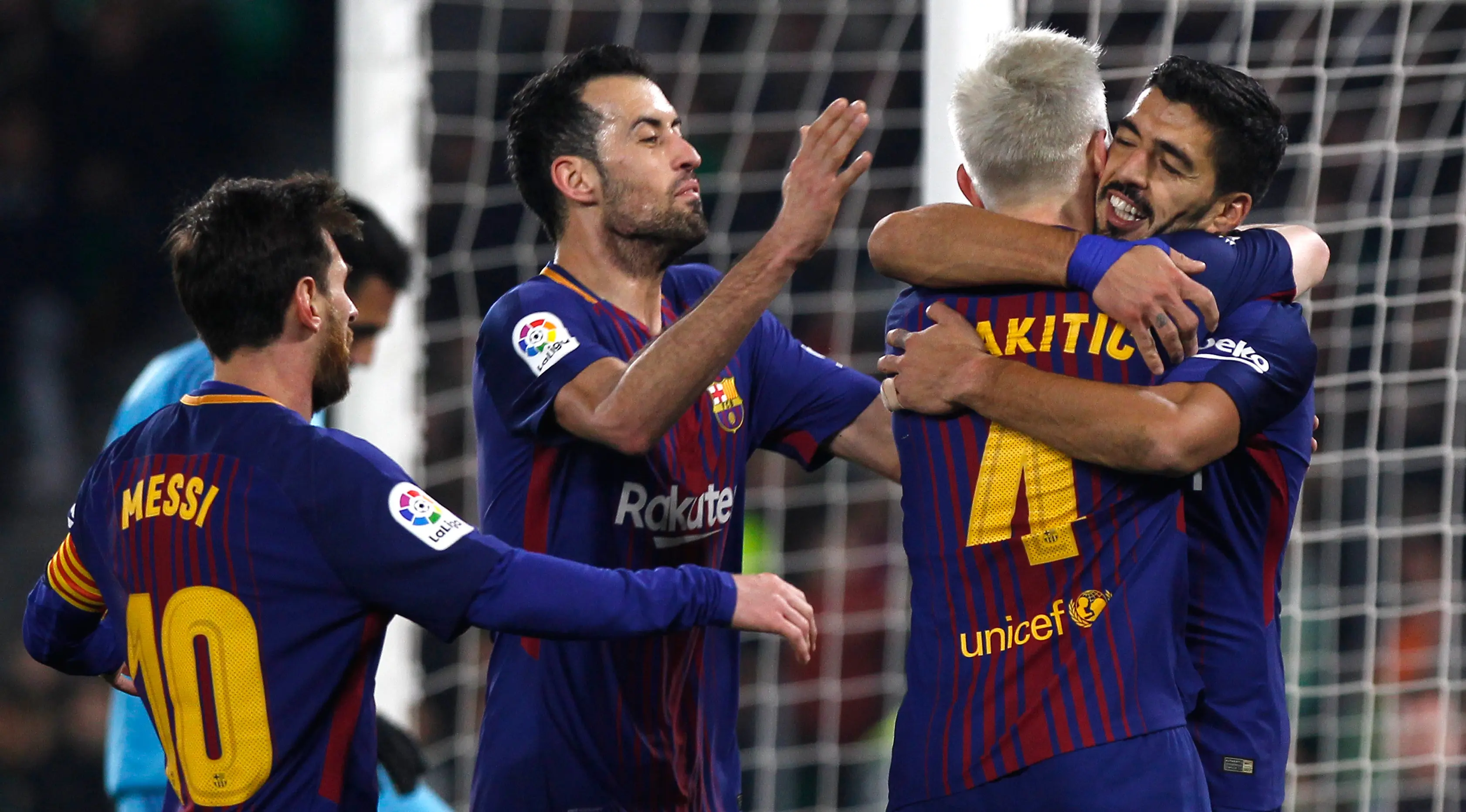 Pemain Barcelona, Luis Suarez dan rekan setimnya, Ivan Rakitic merayakan gol ke gawang Real Betis pada pertandingan lanjutan La Liga di Stadion Benito Villamarin, Minggu (21/1). Barcelona menyegel kemenangan dengan skor 5-0. (AP/Miguel Morenatti)