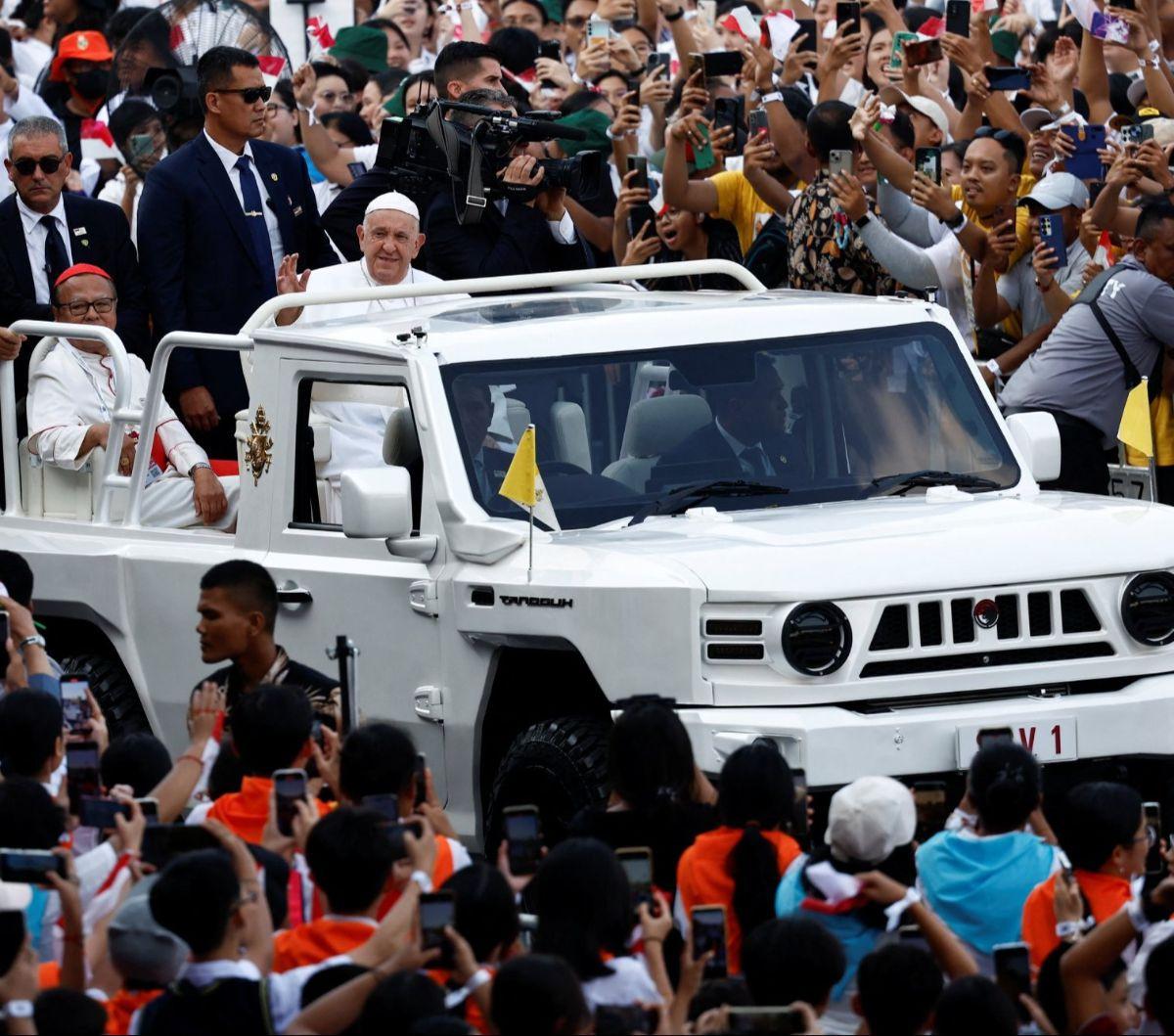Pemimpin Tertinggi Gereja Katolik Sedunia, Paus Fransiskus melambaikan tangan dari atas kendaraan taktis Maung MV3 buatan PT Pindad saat menyapa para jemaat Misa Suci di Stadion Gelora Bung Karno (GBK), Jakarta, Kamis (5/9/2024). Misa akbar yang dipimpin 