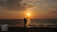 Wisatawan menikmati keindahan sunset di Pantai Sengigi, NTB (13/10/2015). Pulau Lombok terpilih sebagai pemenang dalam ajang internasional World’s Best Halal Travel Summit di Abu Dhabi, Uni Emirate Arab (UEA).(Liputan6.com/Gempur M Surya)