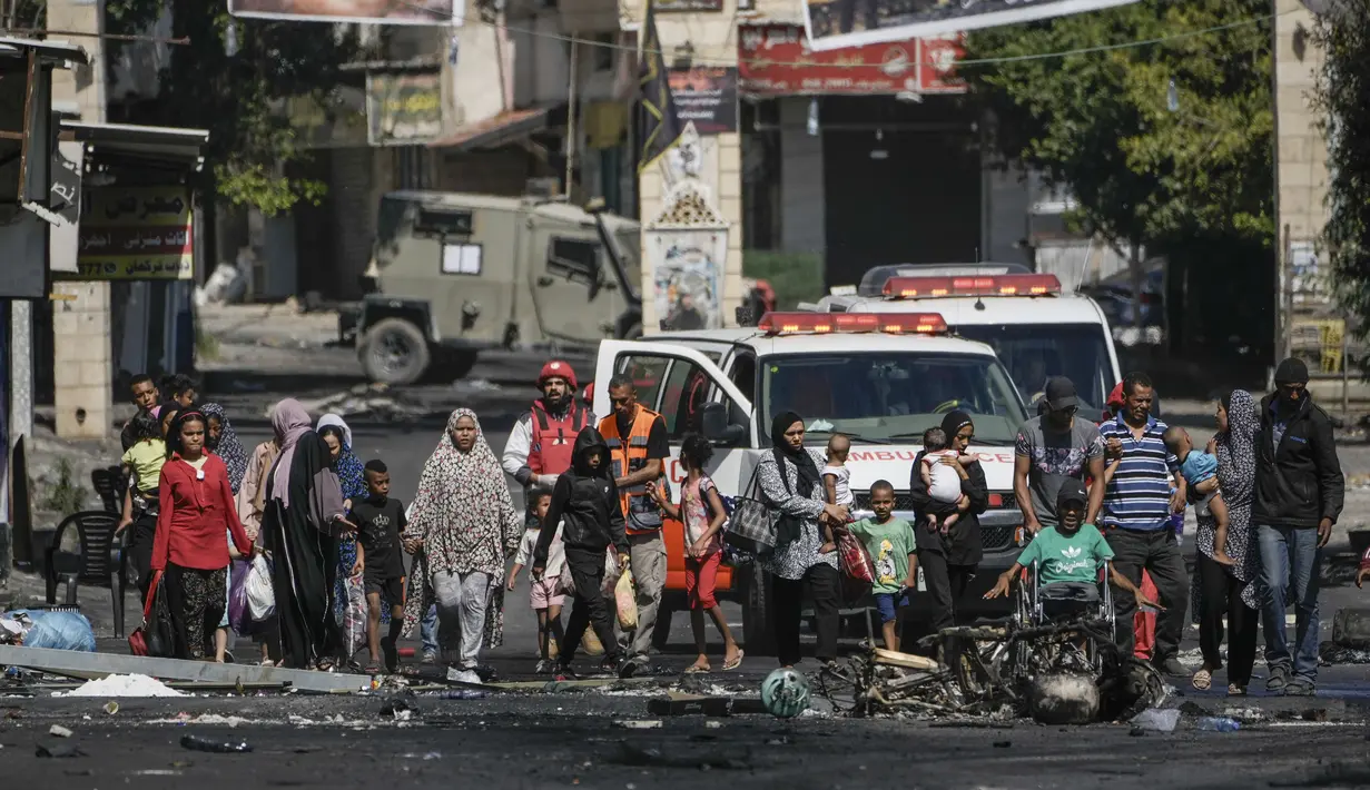 Penduduk kamp pengungsi Jenin meninggalkan rumah mereka ketika militer Israel melanjutkan operasi di daerah itu pada Selasa, 4 Juli 2023. (AP Photo/Majdi Mohammed)