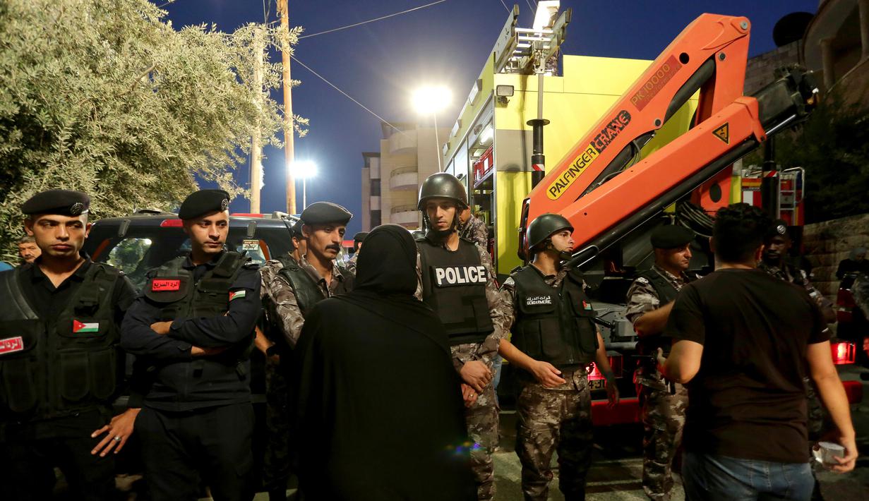 Polisi Yordania mengepung daerah di mana Pertahanan Sipil Yordania melakukan operasi pencarian terhadap penghuni sebuah bangunan tempat tinggal berlantai empat yang runtuh, di Amman, Yordania, Selasa (13/9/2022). Direktorat Keamanan Publik mengatakan tim penyelamat masih mencari korban selamat. (AP Photo/Raad Adayleh)