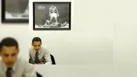 Obama di ruang kerja pribadinya. Di belakangnya tertera foto Muhammad Ali. (AFP)