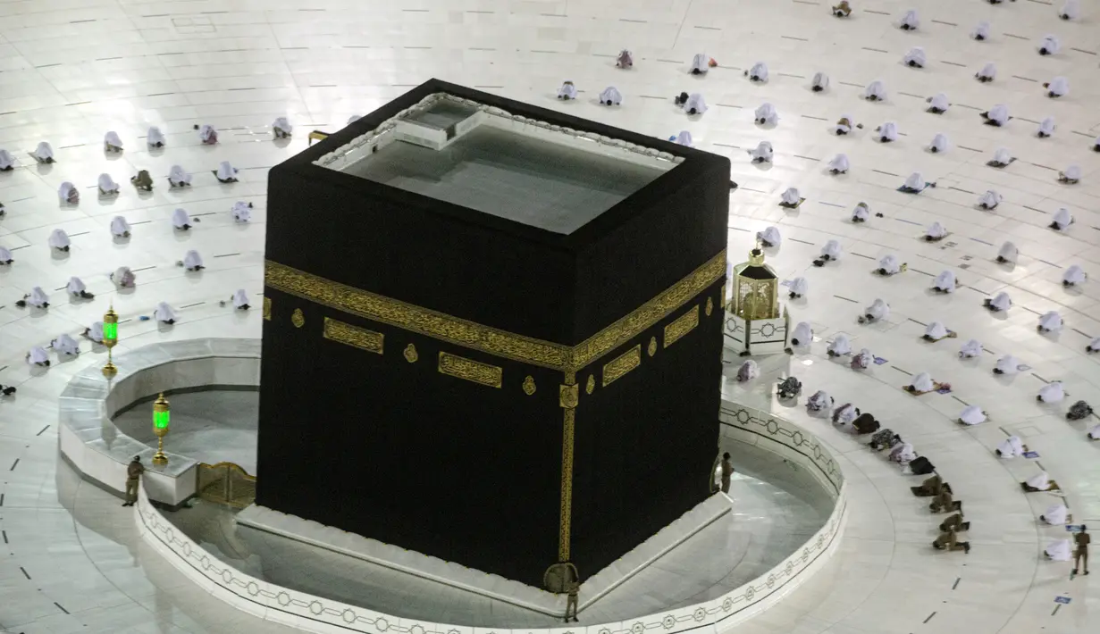 Jemaah umrah menerapkan jaga jarak untuk membantu mengekang penyebaran virus corona COVID-19 saat sholat mengelilingi Ka'bah pada awal bulan suci Ramadhan di Masjidil Haram, Mekkah, Arab Saudi, Senin (12/4/2021). (AP Photo/Amr Nabil)