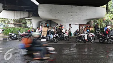 Pengendara sepeda motor berteduh di bawah flyover saat hujan turun, Jakarta, Senin (16/11). Memasuki musim hujan, polisi meminta pengendara untuk tidak berteduh di sembarang tempat, khususnya di bawah fly over. (Liputan6.com/Immanuel Antonius)