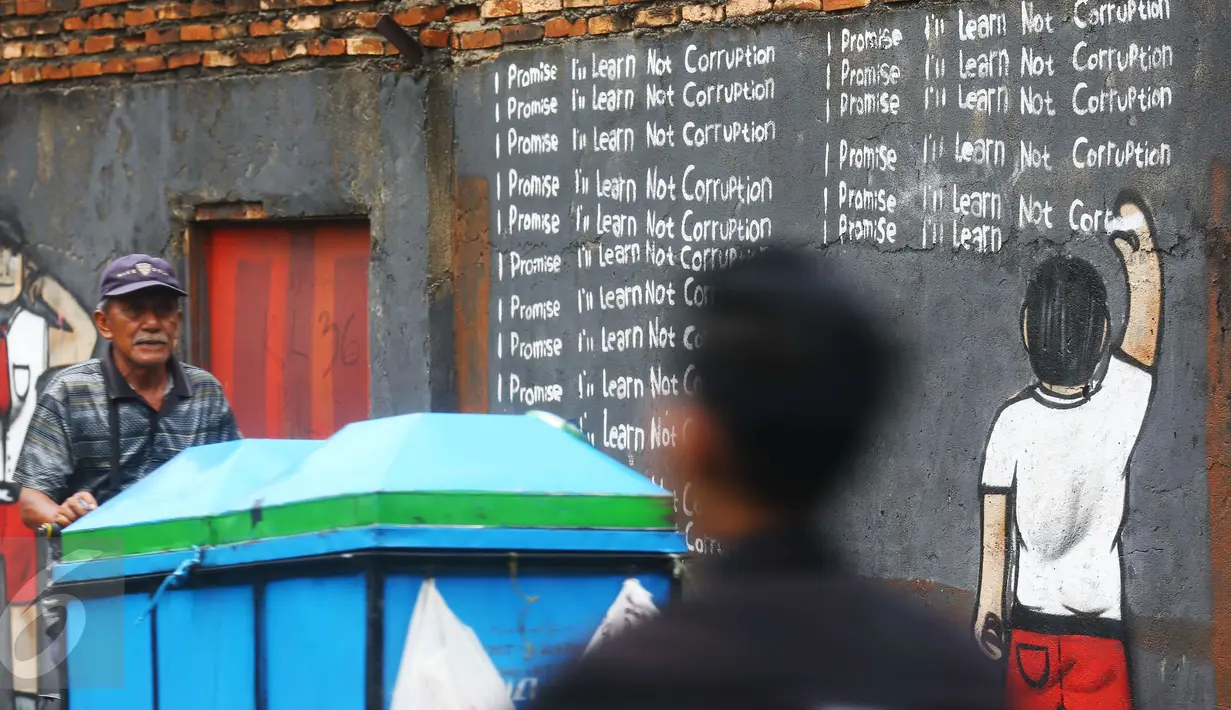 Seorang pedagang kerupuk mengendarai gerobaknya melintas di depan mural anti korupsi bertuliskan 'I promise i'll learn not corruption' atau 'Saya berjanji saya akan belajar untuk tidak korupsi' di Jakarta, Minggu (05/03). (Liputan6.com/Helmi Afandi)