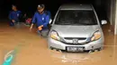 Petugas berusaha mengevakuasi mobil dari parkir basement sebuah pertokoan di Jalan Kemang Raya, Minggu (28/8). Sejumlah kendaraan terendam air di kawasan Kemang Raya pasca hujan deras di Jakarta pada Sabtu (27/8). (Liputan6.com/Helmi Fithriansyah)