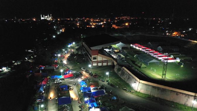 Foto udara menunjukkan tenda-tenda di tempat penampungan darurat di Mamuju (19/1/2021). Basarnas menyebut hingga pukul 16.00 WIB, Senin (18/1/2021) sebanyak 84 orang meninggal akibat gempa yang terjadi di Sulawesi Barat (Sulbar). (AFP/Adek Berry)