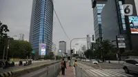 Sejumlah pekerja berjalan di kawasan Jalan Sudirman, Jakarta, Selasa (2/11/2021). Sektor non-esensial kini boleh mempekerjakan hingga 75 persen karyawannya dari kantor. Sebelumnya, angka ini dibatasi hingga 50 persen. (Liputan6.com/Faizal Fanani)