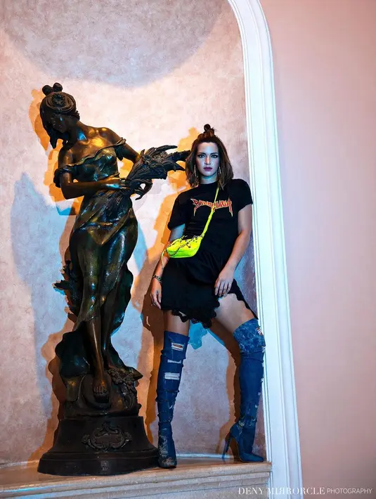 Sementara pada potret ini, Nia Ramadhani tampil lebih muda meski dengan look rock and roll. Memadukan t-shirt dan satin skirt berwarna hitam, lengkap dengan high tight boots denim. Look ini bisa menjadi inspirasi untuk nonton konser. (instagram/denymirrorcle)