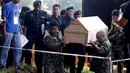 Petugas kepolisian Malaysia membawa peti mati jenazah yang di duga etnis Rohingya ke pemakaman massal di Alor Setar, Malaysia, Senin (22/6/2015).  21 dari 106 jenazah tak dikenal yang ditemukan bulan lalu dimakamkan hari ini. (Reuters/Olivia Harris)