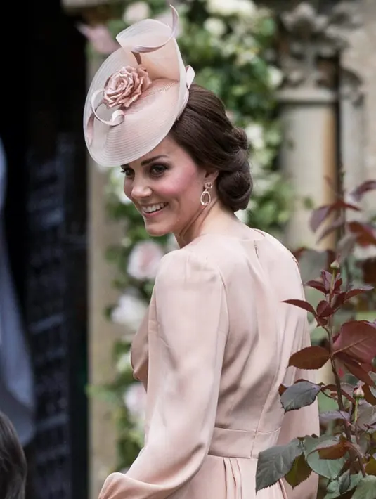 Senyum Kate Middleton saat menghadiri pernikahan Pippa Middleton dan James Mathews di Gereja St. Mark, barat London, Sabtu (20/5). Kate melengkapi penampilannya ala bangsawan Inggris lewat topi pink dari Jane Taylor. (AP Photo/Kirsty Wigglesworth, Pool)
