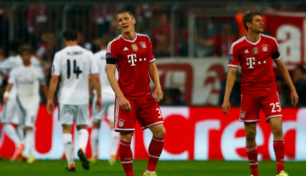 Bastian Schweinsteiger dan Thomas Mueller terlihat lesu usai Cristiano Ronaldo mencetak gol keempat buat Real Madrid yang memupuskan peluang Bayern Munich mempertahankan gelar juara Liga Champions, di Allianz Arena, (30/4/2014). (REUTERS/Michael Dalder)