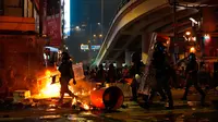 Polisi antihuru-hara tiba setelah demonstran membakar sampah di Hong Kong, Minggu (29/9/2019). Demonstrasi pada akhir pekan ini sendiri digelar beberapa hari menjelang perayaan kemerdekaan China. (AP Photo/Vincent Yu)