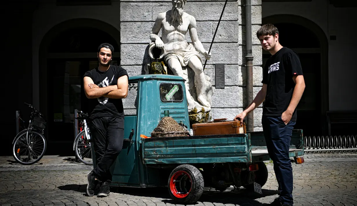 Dua orang pria berdiri dekata Ape saat pameran memperingati 70 tahun Ape di Aosta, Italia utara (1/7). Dalam acara ini pemilik dan kolektor Piaggio Ape berkumpul untuk merayakan ulang tahun Ape yang ke-70. (AFP Photo/Marco Bertorello)