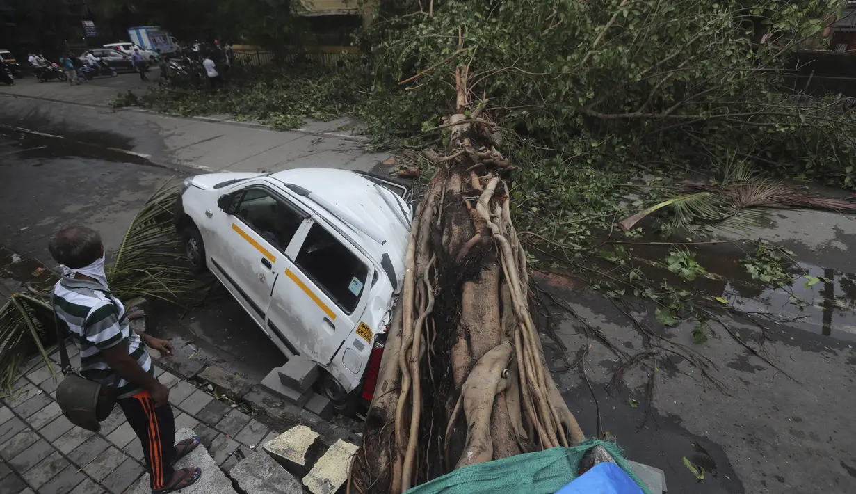 Sebuah mobil tertimpa pohon yang tumbang setelah hujan lebat akibat siklon Tauktae di Mumbai India, pada Selasa (18/5/2021). Topan Tauktae disebut yang terbesar melanda wilayah itu dalam beberapa dekade terakhir.  (AP Photo/Rafiq Maqbool)