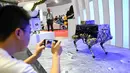 Pengunjung mengambil gambar robot berkaki empat dalam Konferensi Robot Dunia 2019 di Beijing, China, Selasa (20/8/2019). (WANG Zhao/AFP)