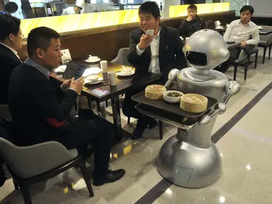Sebuah robot menyajikan makanan di restoran Robot di Hefei, China, Jumat (26/12/2014). (REUTERS/Stringer)