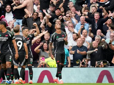 Pemain Arsenal, Gabriel Magalhaes (kanan) melakukan selebrasi dengan rekan setimnya setelah mencetak gol pembuka saat pertandingan Liga Premier Inggris melawan Tottenham Hotspur di London, Minggu 15 September 2024. (AP Photo/Kin Cheung)