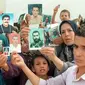 Keluarga-keluarga tersebut mengangkat foto orang yang mereka cintai yang hilang di tengah perang saudara di Aljazair, selama demonstrasi mingguan di Aljir pada bulan September 1998 (Sumber: AFP)