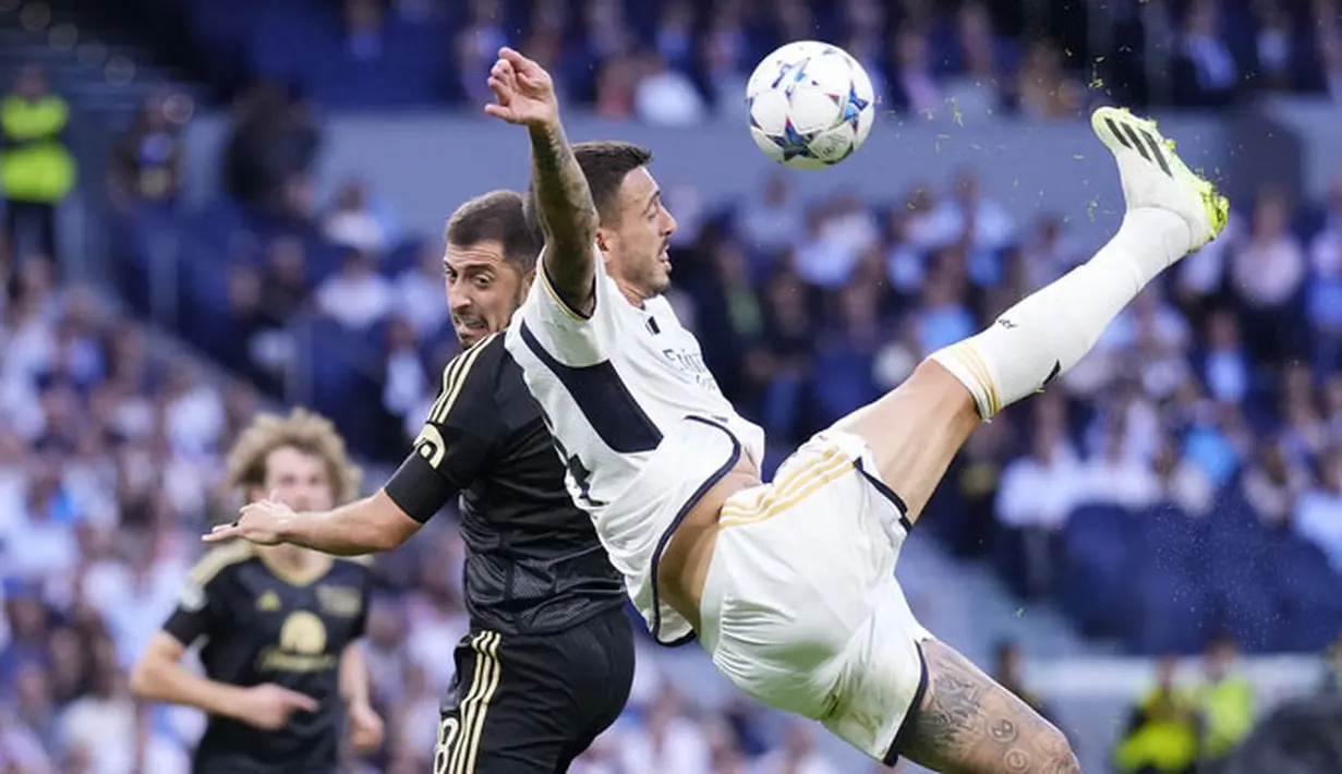 Pemain Real Madrid, Joselu, berebut bola dengan pemain Union Berlin, Josip Juranovic, dalam matchday 1 Grup C Liga Champions 2023/2024, di Stadion Santiago Bernabeu, Madrid, Rabu (20/9/2023). Los Blancos menang dengan skor 1-0. (AP Photo/Manu Fernandez)