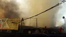 Petugas pemadam kebakaran berupaya memadamkan api yang membakar sebuah percetakan dan pabrik roti di Jalan Cawang Baru, Kavling Otista, Jakarta, Selasa (19/9). Sekitar 10 unit mobil damkar diturunkan untuk memadamkan api. (Liputan6.com/Angga Yuniar)