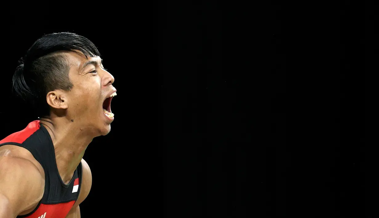 Ekspresi Deni, atlet angkat besi asal Indonesia saat berhasil melakukan angkatan di kelas 77kg Olimpiade 2016 Rio de Janeiro, Brasil, Rabu (10/8). Deni gagal menambah perolehan medali kontingen Indonesia di Olimpiade 2016. (REUTERS/Athit Perawongmetha)