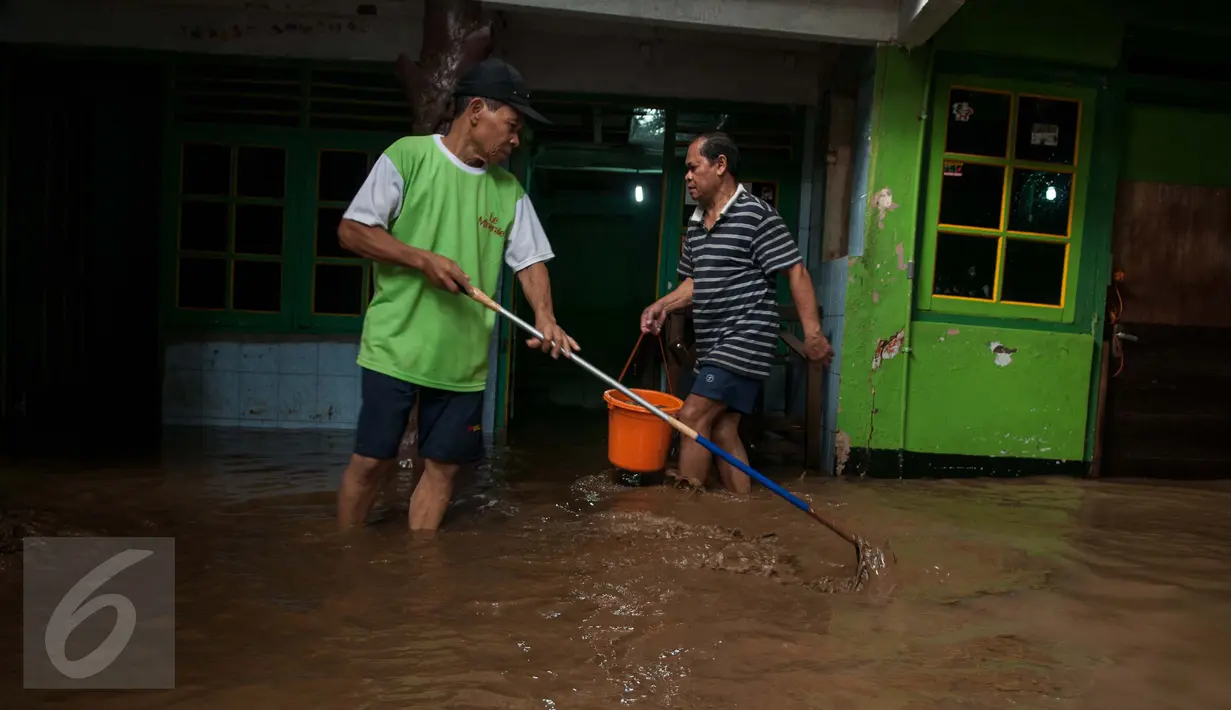 Warga membersihkan lumpur yang memenuhi rumahnya di Jalan Taman Harapan rt 02/03, Cawang, Kramat Jati, Jakarta, Senin (13/2). Warga mulai membersihkan lumpur setelah banjir yang menggenangi pemukiman mereka surut. (Liputan6.com/Gempur M Surya)