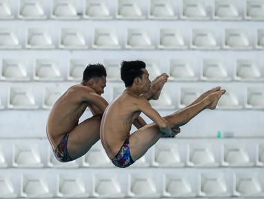 Pasangan atlet loncat indah, Andriyan (kanan) dan Adityo Restu Putra beraksi pada nomor menara synchro putra Kejurnas Akuatik 2026 di Stadion Akuatik Gelora Bung Karno, Senayan, Jakarta, Selasa (05/05/2026). (Bola.com/Bagaskara Lazuardi)