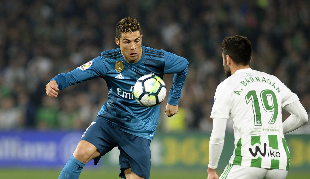 Gaya bintang Real Madrid, Cristiano Ronaldo (kiri) melewati adangan pemain Real Betis, Antonio Barragan pada lanjutan La Liga Santander di Villamarin stadium,Seville, (18/2/2018). Real Madrid menang 5-3. (AFP/Cristina Quicler)