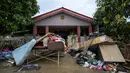 Puing dan harta benda terlihat di luar rumah setelah air banjir surut di Mentakab, negara bagian Pahang, Malaysia (11/1/2020).  Banjir awal tahun 2021 ini merupakan yang terparah dalam beberapa dekade terakhir. (AFP/Mohd Rasfan)