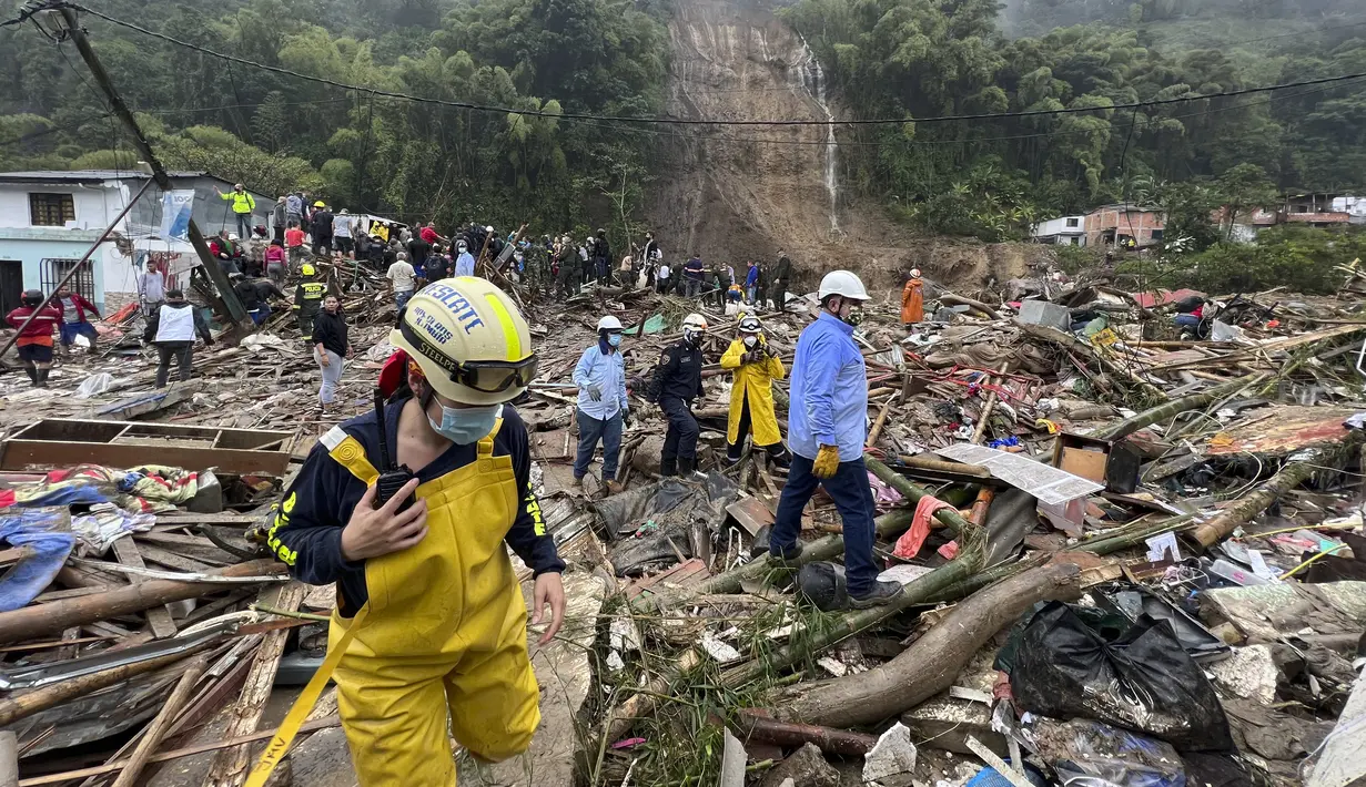 Petugas penyelamat mencari korban selamat di mana lereng bukit yang diguyur hujan runtuh menimpa rumah-rumah penduduk di Pereira, Kolombia, Selasa (8/2/2022). (AP Photo/Andres Otalvaro)