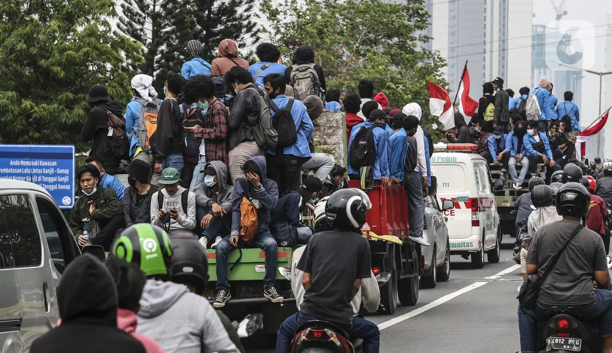 Mahasiswa menaiki sejumlah truk saat konvoi menuju Gedung DPR/MPR, Jakarta, Kamis (8/10/2020). Mahasiswa ini rencananya akan menggelar aksi menolak UU Cipta Kerja. (Liputan6.com/Johan Tallo)