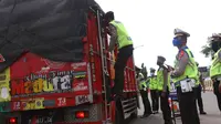Petugas kepolisian melakukan pengecekan terhadap truk yang keluar Tol Merak, Banten, Senin (18/5/2020). Pemeriksaan (check point) tersebut terkait larangan mudik guna penyekatan atau memeriksa kemungkinan pemudik yang akan keluar dari wilayah Jabodetabek. (Liputan6.com/Angga Yuniar)