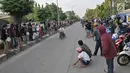 Warga menonton seorang pembalap saat memacu motornya dalam balapan liar di Jakarta, Minggu (27/5) pagi. Mereka memanfaatkan sepinya arus lalu lintas kendaraan untuk balapan liar. (Merdeka.com/Iqbal S Nugroho)