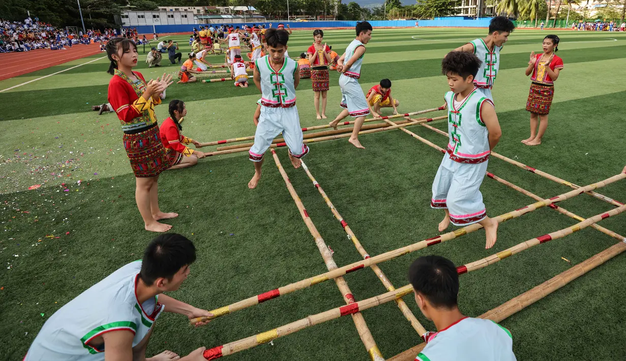 Para pelajar mengikuti kompetisi tari bambu di Sekolah Menengah Baoting yang berada di Wilayah Otonom Etnis Li dan Miao Baoting, Provinsi Hainan, China selatan, pada 18 November 2020. (Xinhua/Zhang Liyun)