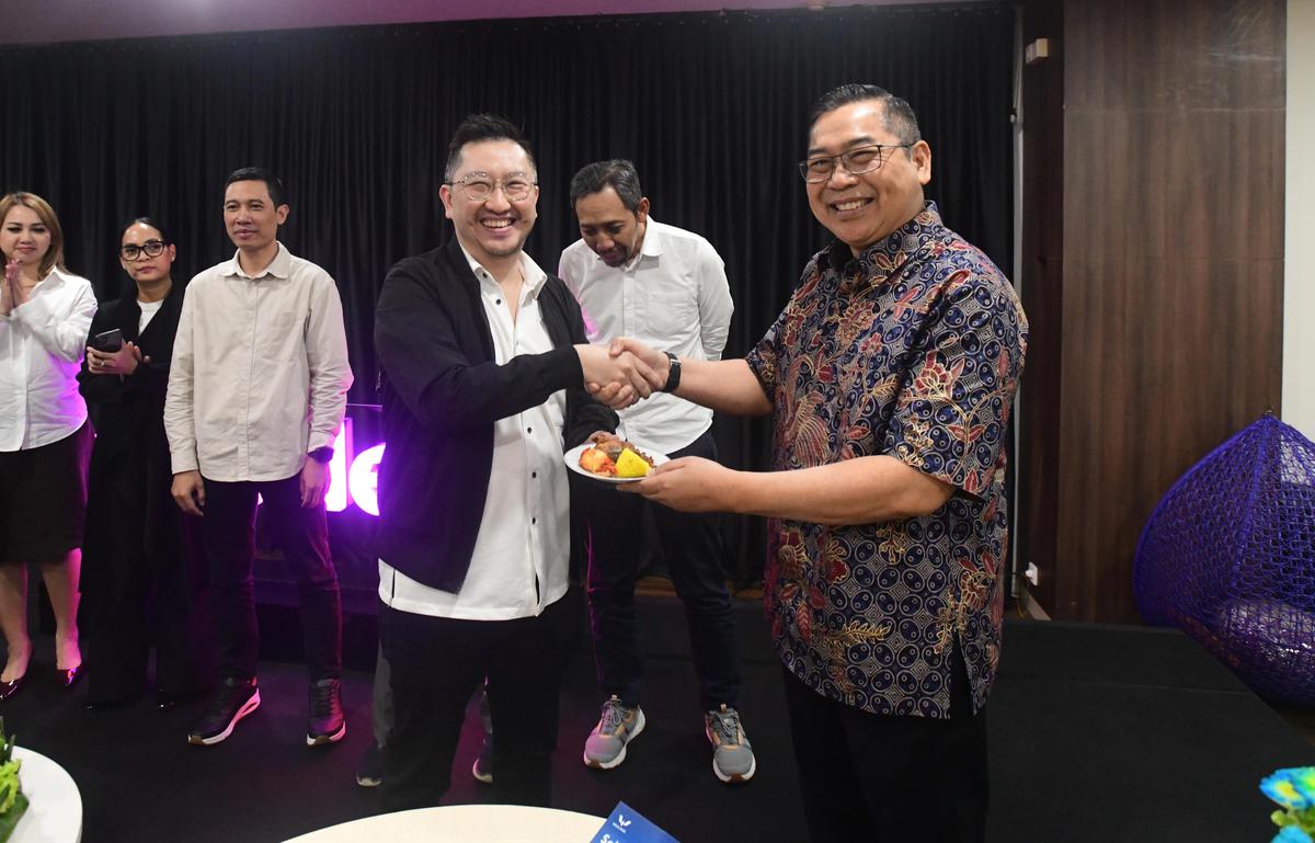 CEO Kapanlagi Universi (KLY) Danny Purnomo (kanan) menyerahkan nasi tumpeng kepada Corporate Secretary SCMA, Gilang Iskandar saat ulang tahun ke 14 Merdeka.com di Gedung KLY, Jakarta, Senin (23/02/2026)