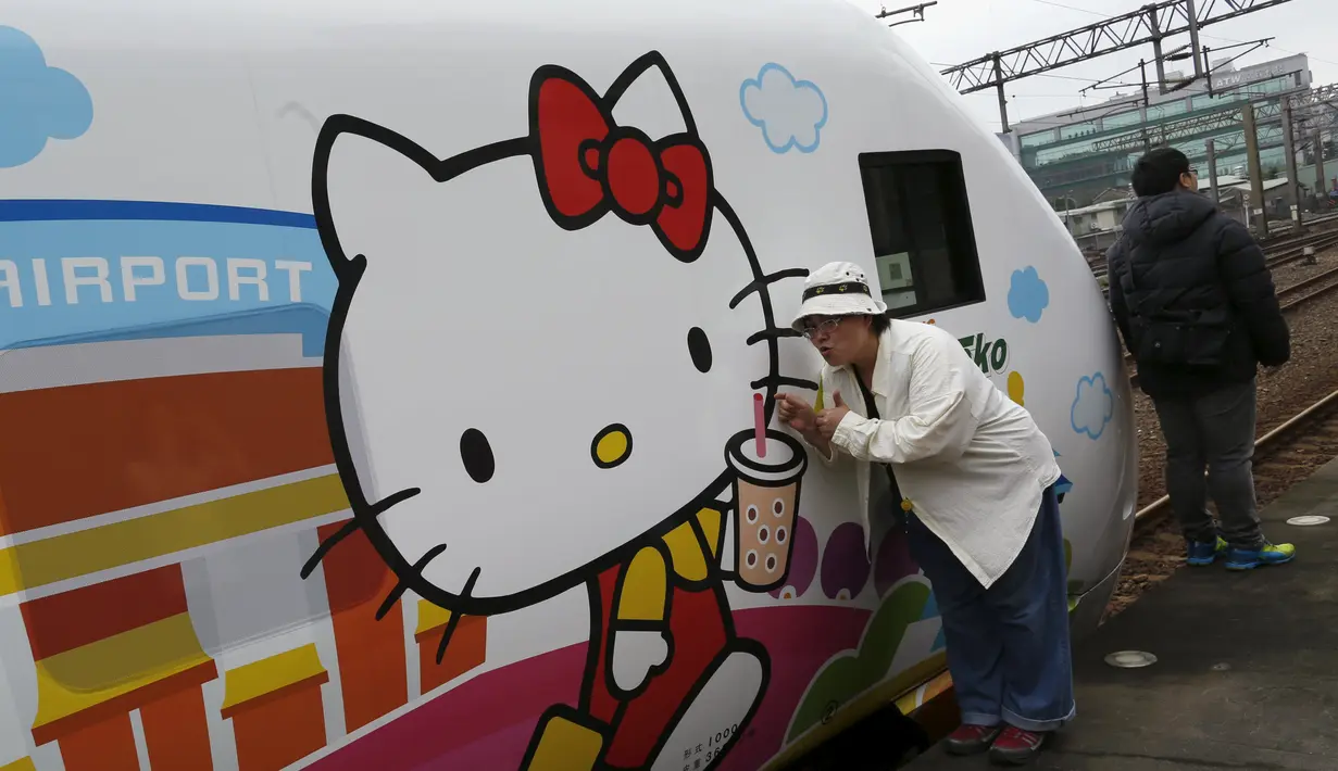 Seorang wanita berpose disamping kereta Taroko Ekspres yang bertemakan Hello Kitty di Taipei, Taiwan, Senin (21/3). Kereta tersebut akan melakukan perjalanan perdananya dari Taipe ke Taitung. (REUTERS/Tyrone Siu)