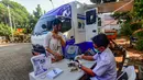 Dokter hewan melakukan penyuntikan vaksin anti rabies kucing peliharaan warga pada unit mobil Klinik Hewan Keliling di halaman Kantor Kelurahan Srengseng sawah, Jakarta Selatan, Rabu, 15/ Juli 2026. (KLY/ Arie Basuki)