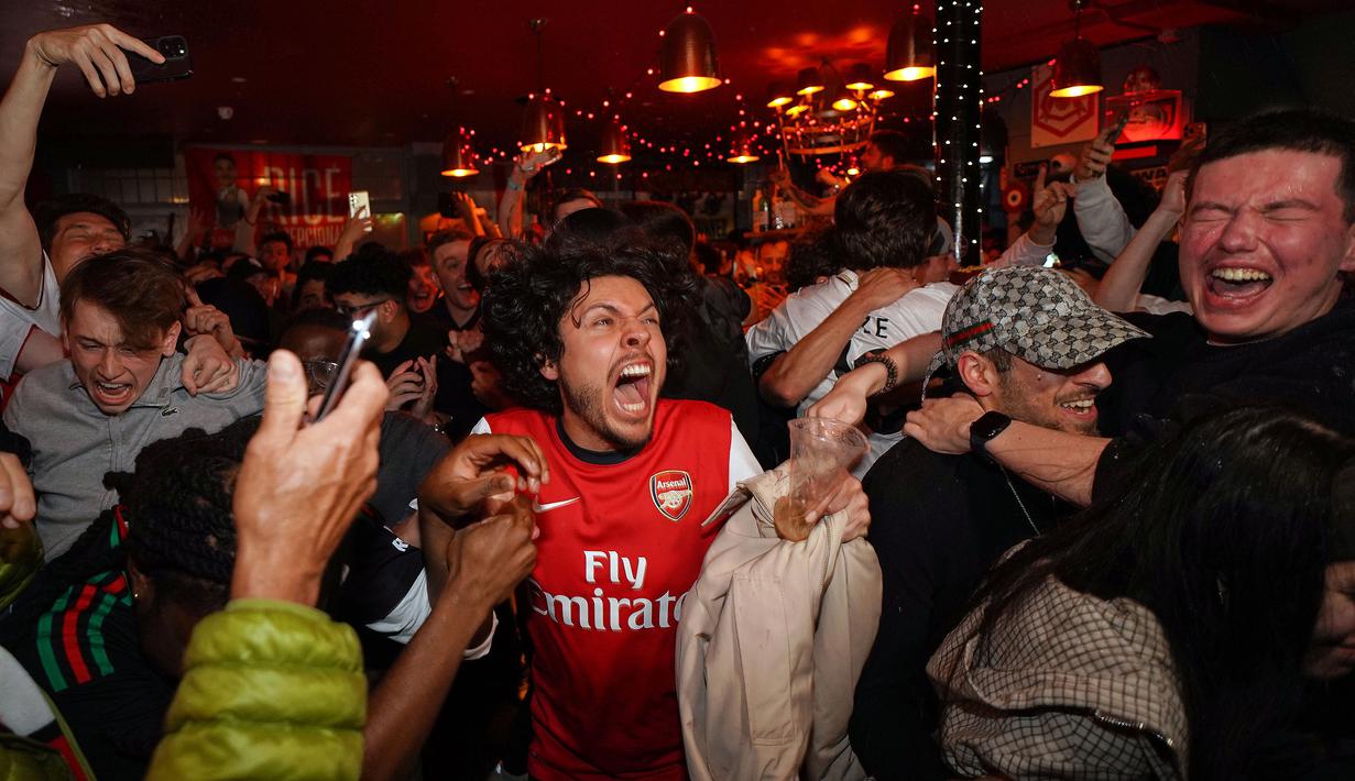 Suka cita menyelimuti para suporter Arsenal setelah The Gunners memastikan diri sebagai juara Liga Inggris musim 2025/2026. (AP Photo/Alberto Pezzali)